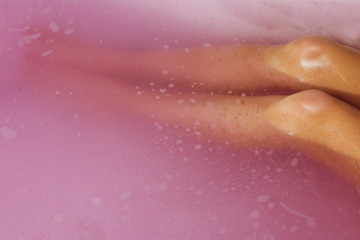 top view close up beautiful legs in pink bubble water/ room for text/ home spa