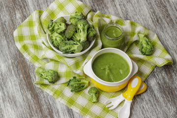 Fresh broccoli in the bowl, and portion of puree made from crushed broccoli, blurred background