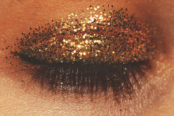 close up eye gold glitter eyeshadow/ beauty background/ fashion makeup background