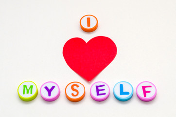 I love myself phrase made from colorful circles with letters and a red heart against white background