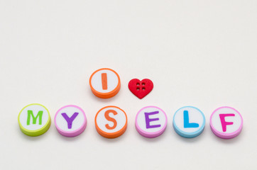 I love myself phrase made from colorful circles with letters and a heart shape button against white background