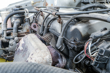 A detail of the old car wreck. The engine with spark plugs. The oil leak is on it. 