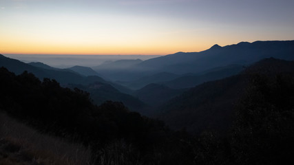 Fototapeta premium Sun rising on a foggy dark mountain range silhouette in Catalan Pyrenees