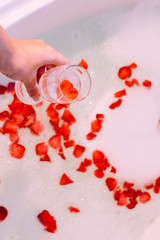 Romantic bath with rose. St. Valentine's Day bath. Aromatherapy with flower petals.