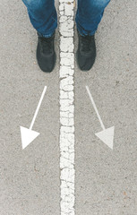 Feet of man in a line with arrows as a concept of making decisions, doubts or moral dilemmas