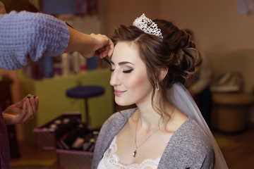 girl in tiara and veil. Bride at a wedding gathering. Preparation, work of the stylist, a wedding...