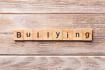 Bullying word written on wood block. Bullying text on wooden table for your desing, concept