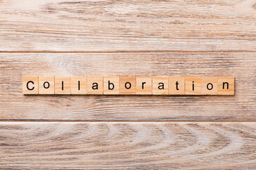 Collaboration word written on wood block. Collaboration text on wooden table for your desing,...