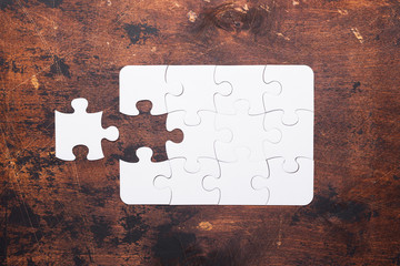 Jigsaw Puzzle with missing piece on old wooden background Top view