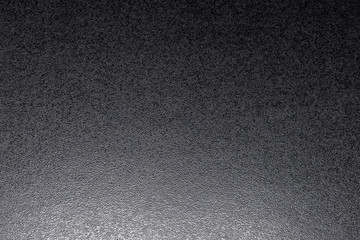 Closeup of black, rough background lit with dim light.