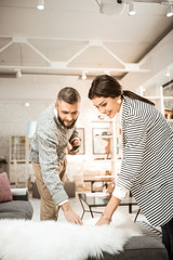 Obraz premium Curious cheerful couple inspecting piece of fur on fluffiness