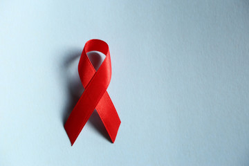 Red ribbon as symbol of aids awareness on blue  background