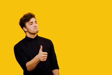 attractive and satisfied man, showing positive gesture with his thumb, satisfied human emotion,...