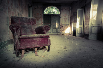 Poltrona rosso in una casa abbandonata