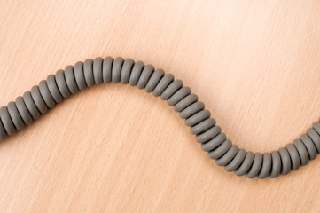 Phone cord on wooden table.