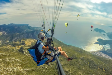 Ölüdeniz    Paragliding in the sky. Paraglider tandem flying over the sea with blue water and...