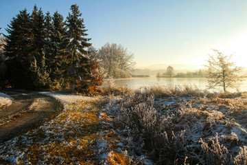 A view from the pond in Czech Republic during the warm winter evening. The sun is going down. 