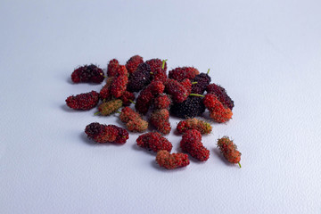 Mulberry fruit mulberry many both purple red orange all laid are on a white background.