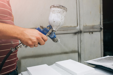 Man is holding airbrush spray vaporizer for painting and dyeing. Worker maintenance repairing of the house or apartment.