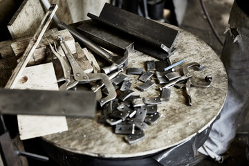 assorted tools and metal pieces in work table