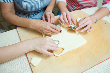 women in the kitchen preparing cookies from the dough
