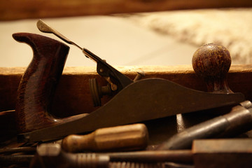 vintage wood plane with other tools in rustic toolbox