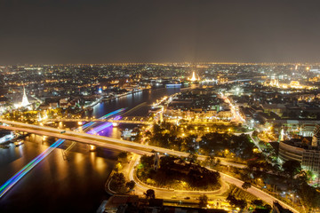 Fototapeta premium Night sky The night sky above the city with both cars and boats moving