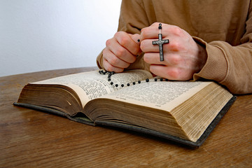 Mann betet den Rosenkranz