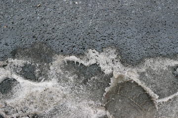 Melting snow asphalt slush water puddle flow dirty street sidewalk