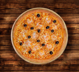 Isolated image of pizza with shrimps and olives on a wooden background