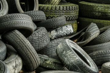 Fototapeta na wymiar A picture of many old used tires left on a waste dump. The picture of an ecological problem and disaster. 