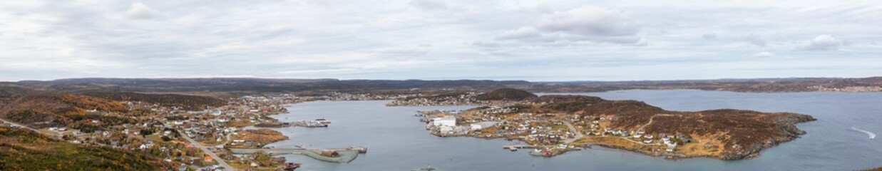 Fototapeta na wymiar Aerial panoramic view of a town on the Rocky Atlantic Ocean Coast during a cloudy morning. Taken in St. Anthony, Newfoundland, Canada.