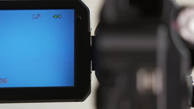 Indicators on LCD screen of digital camcorder while rewinding mini DV cassette tape