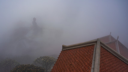 Statue of Buddha and roof of the temple in clouds on Fansipan Mountain, Sapa, Vietnam
