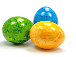Drei gefärbte Hühnereier vor weißem Hintergrund