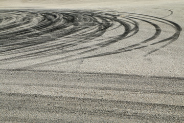 Fototapeta na wymiar The rubber tracks from the rallye cars left on the tarmac in the hairpin. 