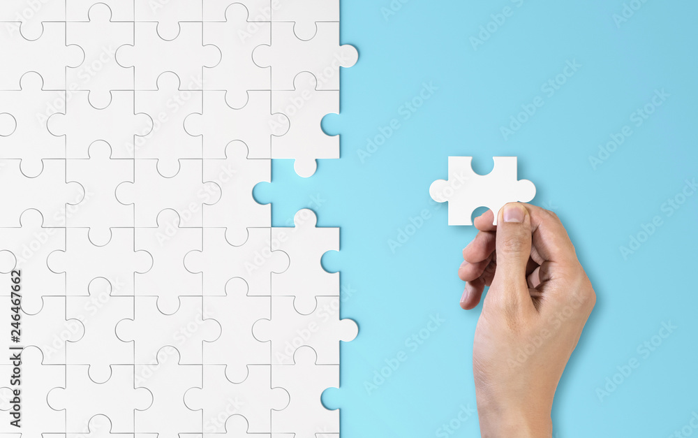 Poster hand putting a piece of white jigsaw puzzle. pattern texture separated in strategy and solution of t