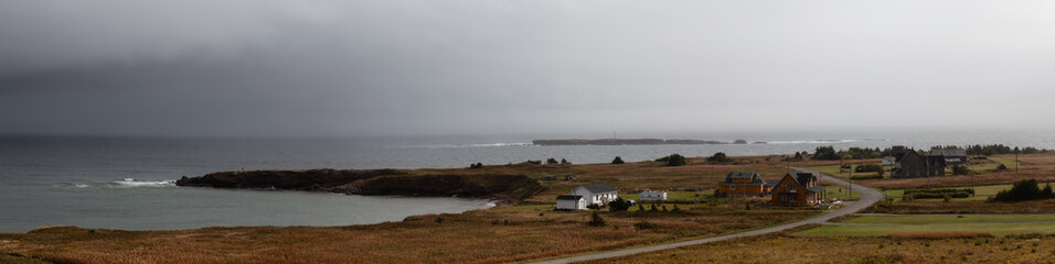 Panoramic view of homes at the Atlantic Ocean Coast during a cloudy day. Taken in Pointe-Saint-Pierre, Quebec, Canada.
