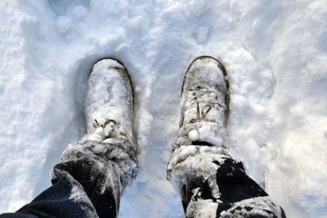 man in jeans and winter shoes in the snow close up