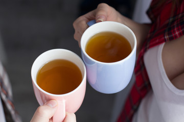 Two people holding coffee mugs.