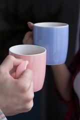 Two people holding coffee mugs.