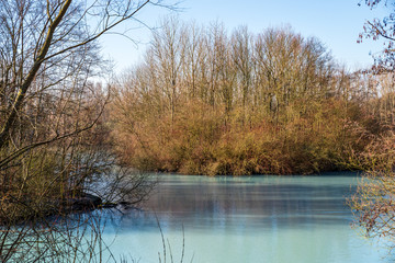 Türkisfarbener Teich im Winter an einem sonnigen Tag