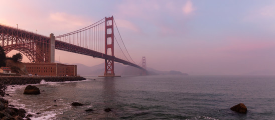 Beautiful view of Golden Gate Bridge during a cloudy sunset. Taken in San Francisco, California, United States.