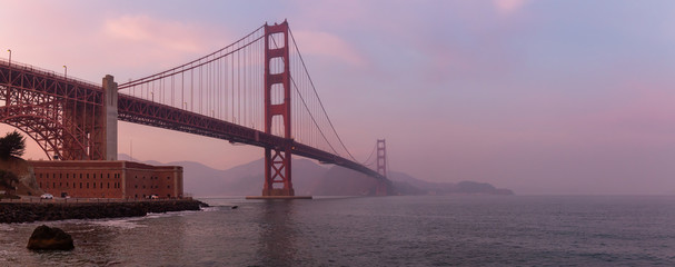 Beautiful view of Golden Gate Bridge during a cloudy sunset. Taken in San Francisco, California, United States.