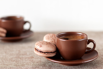 On the table is a cup of coffee with macaroon