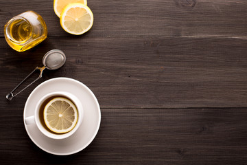 Wooden background with black tea, lemon and honey