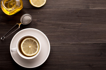 Wooden background with black tea, lemon and honey
