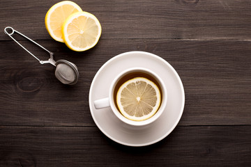 Black tea with lemon on a wooden background