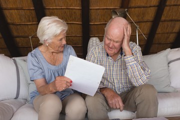 Worried senior couple discussing over medical bills - obrazy, fototapety, plakaty