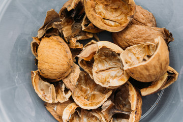 Top view of cracked walnuts shell on wooden background.